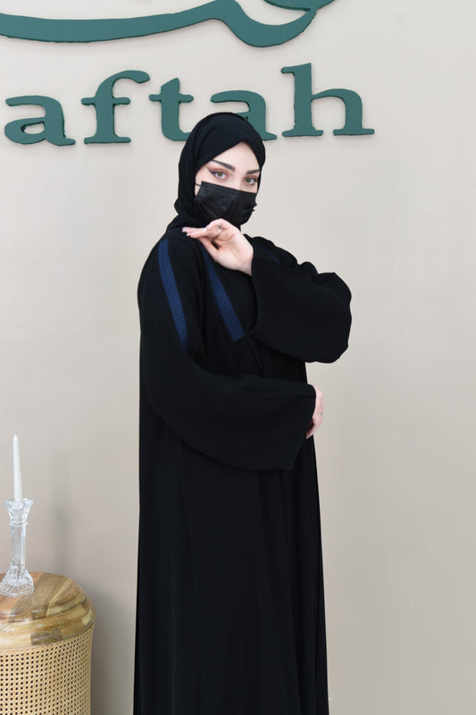 A pleated cloche abaya adorned with navy blue lace trim