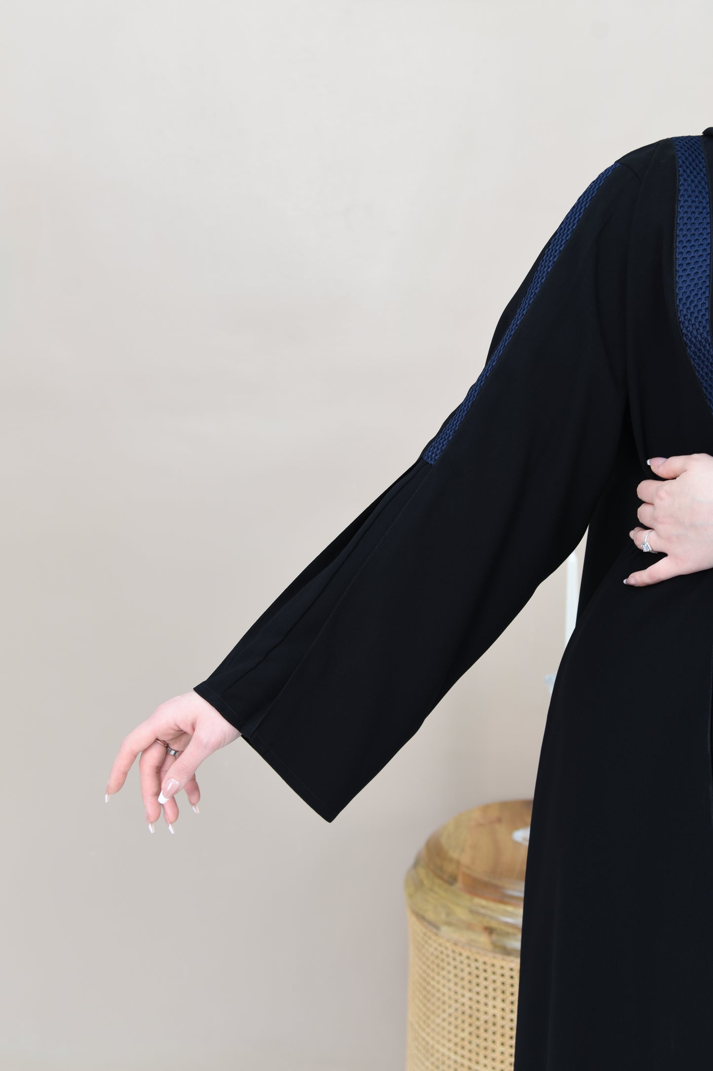 A pleated cloche abaya adorned with navy blue lace trim