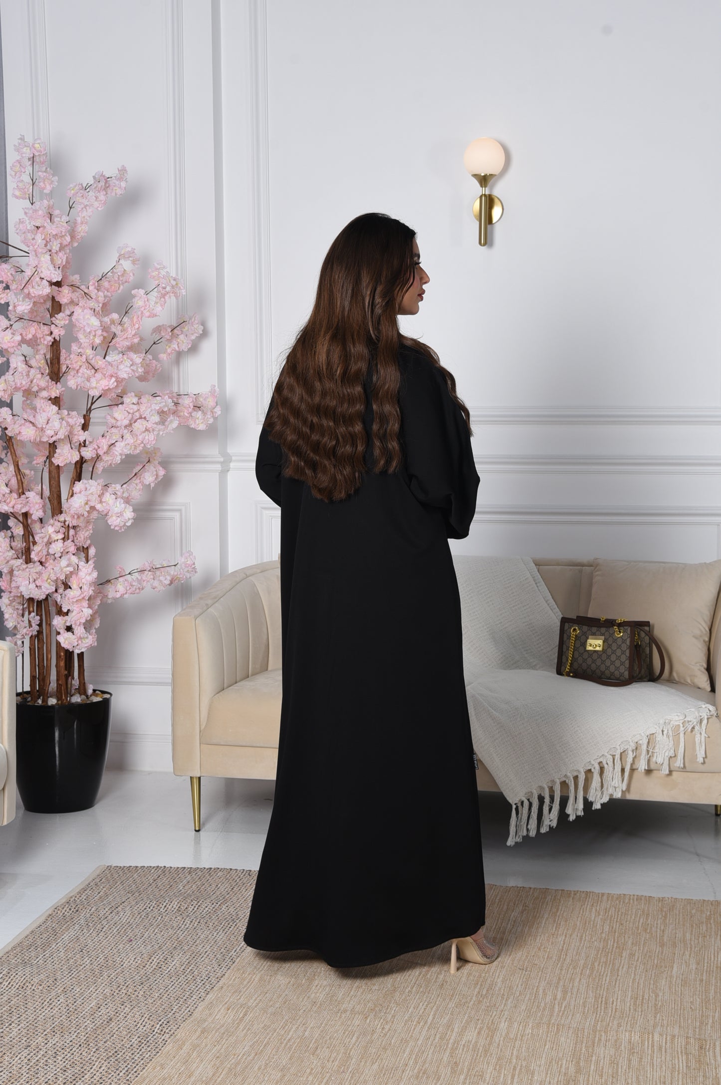 An abaya with pink and gold accents on black crepe fabric