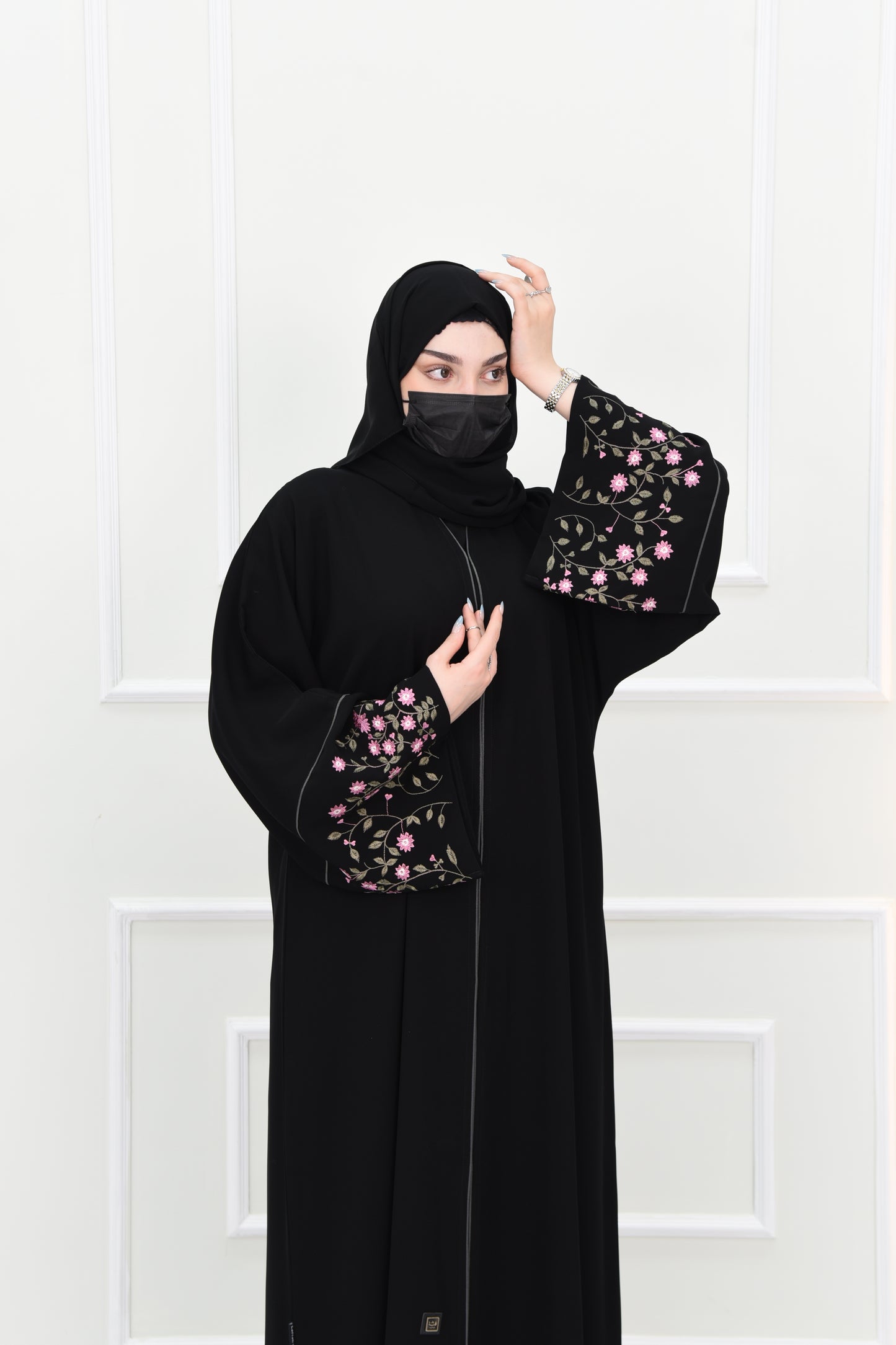 Black abaya adorned with delicate pink embroidery and accented with olive green trim