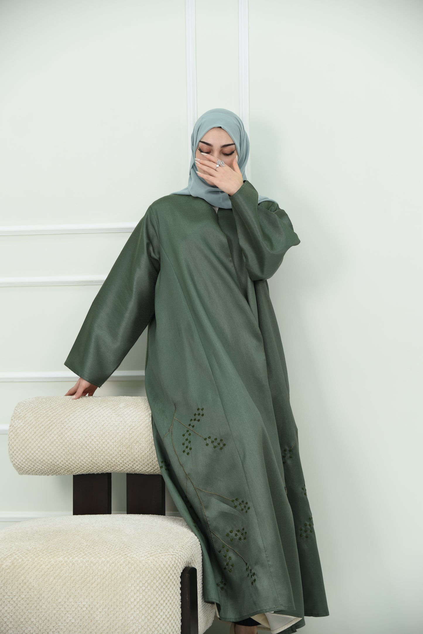 An elegant olive green abaya designed with an exquisite embroidery along the lower hem