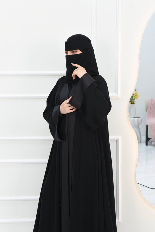 A cloche-style abaya with square sleeves, crafted from satin-blend fabric
