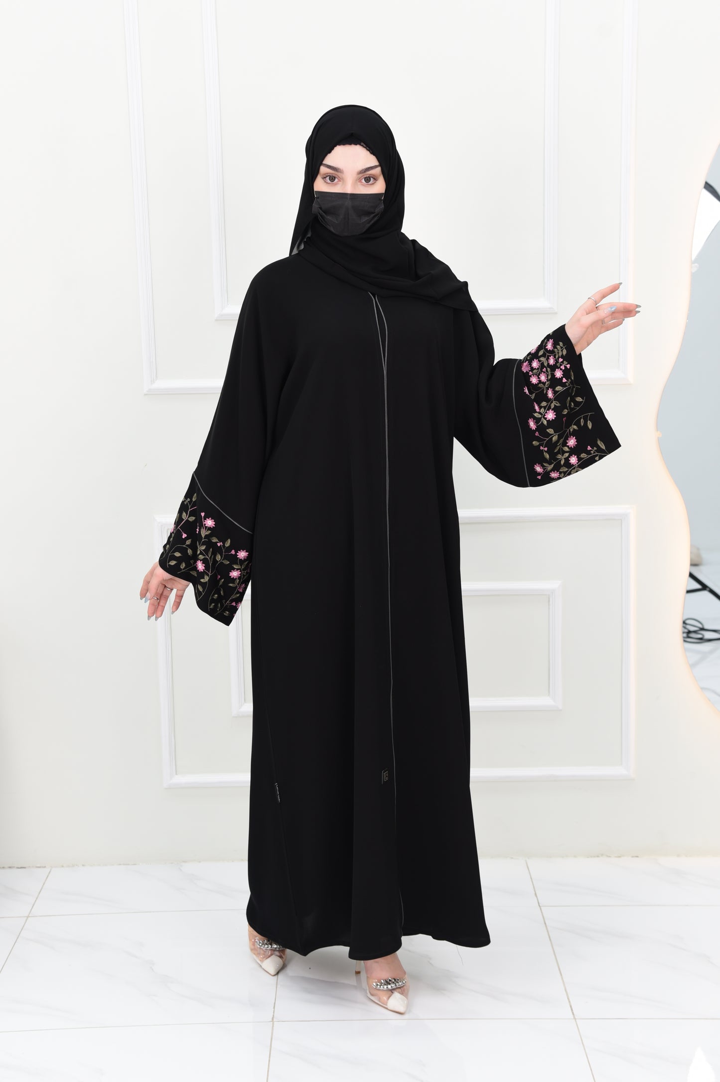Black abaya adorned with delicate pink embroidery and accented with olive green trim