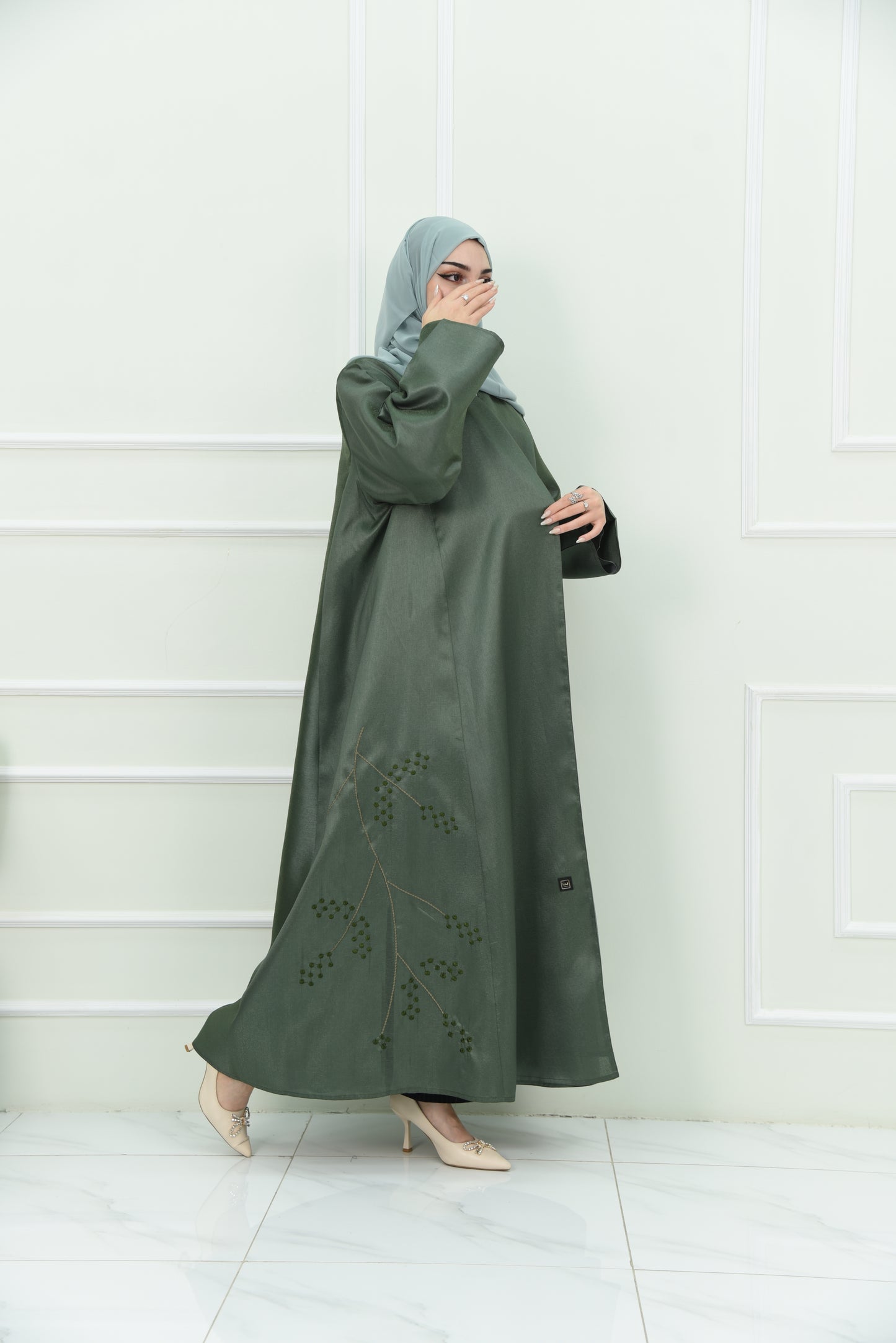 An elegant olive green abaya designed with an exquisite embroidery along the lower hem