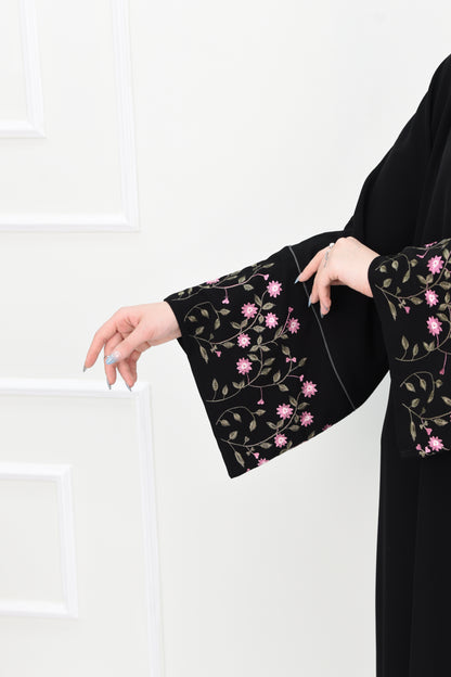 Black abaya adorned with delicate pink embroidery and accented with olive green trim