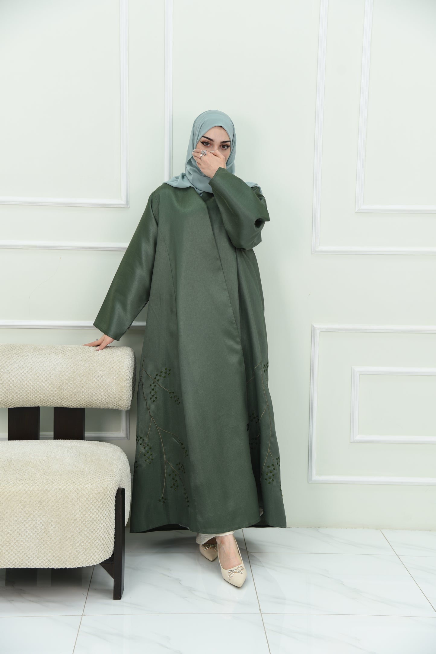 An elegant olive green abaya designed with an exquisite embroidery along the lower hem