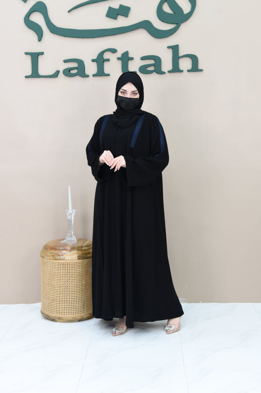 A pleated cloche abaya adorned with navy blue lace trim